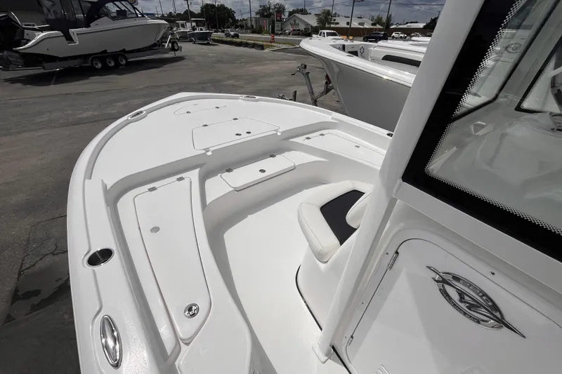Slide: The Image of 2026 Tidewater 2210 Carolina Bay boat, white deck, sleek design, parked outdoors. - 13
