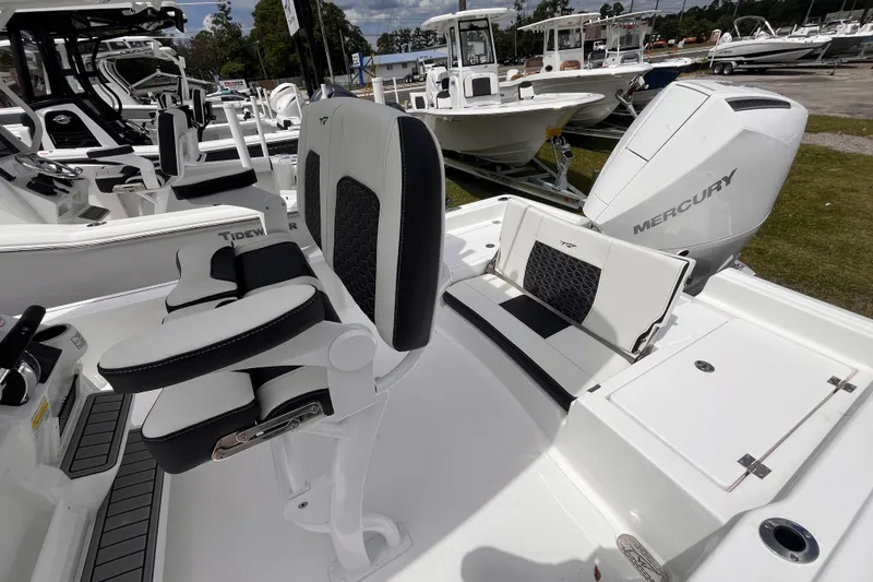 Slide: The Image of 2026 Tidewater 2210 Carolina Bay boat interior with Mercury engine, featuring sleek seating and controls. - 15