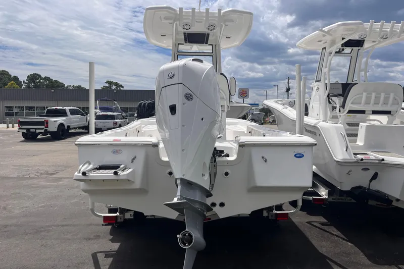 Slide: The Image of 2026 Tidewater 2210 Carolina Bay boat with outboard motor, parked outdoors. - 3