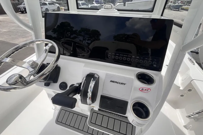Slide: The Image of 2026 Tidewater 2210 Carolina Bay boat console with steering wheel and Mercury controls. - 9