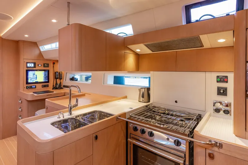 Slide: The Image of Modern kitchen interior of 2018 Nautor Swan 54 yacht, featuring sleek wood cabinetry and stainless steel appliances. - 21