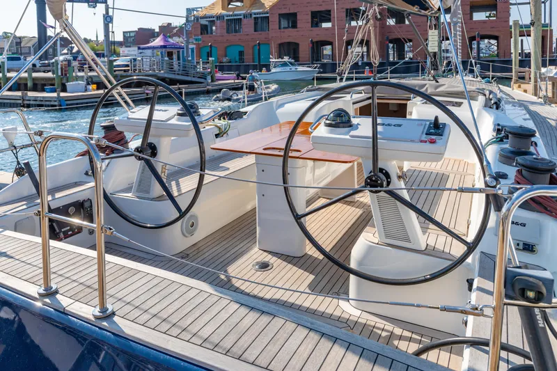 Slide: The Image of 2018 Nautor Swan 54 yacht cockpit with dual steering wheels and wooden deck. - 7