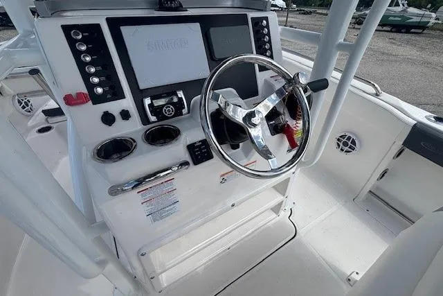 Slide: The Image of 2022 Robalo R222 Explorer boat dashboard with steering wheel and controls. - 11