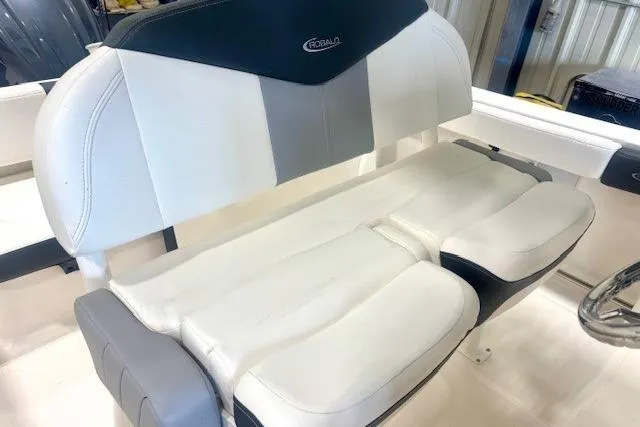 Slide: The Image of 2022 Robalo R222 Explorer boat seat, white and gray upholstery, indoor setting. - 14