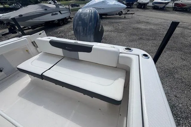 Slide: The Image of 2022 Robalo R222 Explorer boat with cushioned seating and outboard motor in a marina. - 17