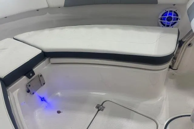 Slide: The Image of 2022 Robalo R222 Explorer boat interior with cushioned seating and blue LED lighting. - 22