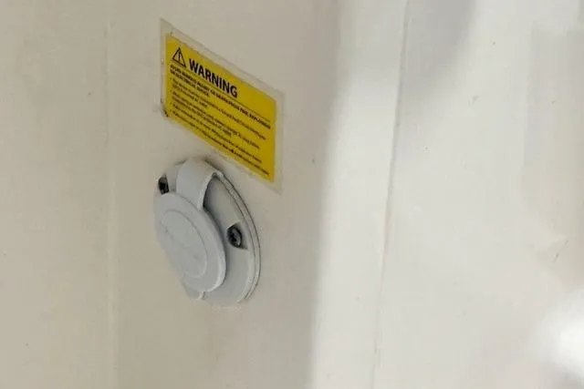 Slide: The Image of 2022 Robalo R222 Explorer boat detail with warning label and circular fixture. - 34