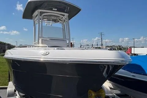 Slide: The Image of 2022 Robalo R222 Explorer boat with T-top, parked outdoors under clear blue sky. - 36