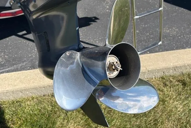 Slide: The Image of 2022 Robalo R222 Explorer boat propeller, shiny metal finish, on grass and pavement background. - 42