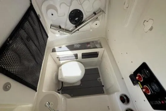 Slide: The Image of 2024 Sailfish 242 CC boat interior with toilet and control panel. - 15