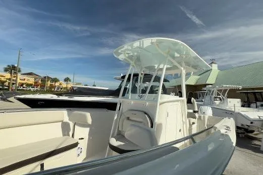 Slide: The Image of 2024 Sailfish 242 CC boat with sleek design, docked under a clear sky. - 16