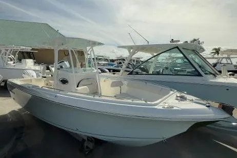Slide: The Image of 2024 Sailfish 242 CC boat displayed at a marina under a cloudy sky. - 2