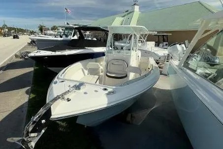 Slide: The Image of 2024 Sailfish 242 CC boat displayed outdoors at a dealership. - 3