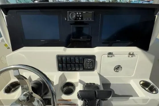 Slide: The Image of 2024 Sailfish 242 CC boat dashboard with dual screens and control panel. - 8