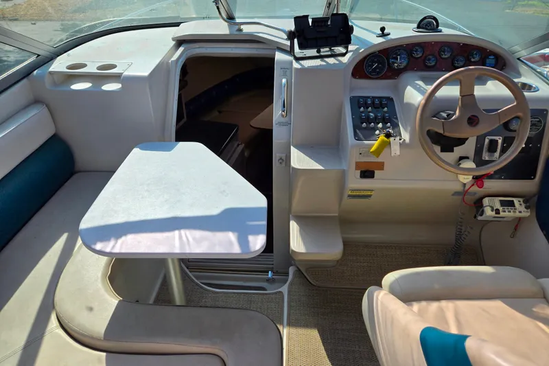 Slide: The Image of Interior of a 1995 Regal Commodore 258 boat with steering wheel and seating area. - 4