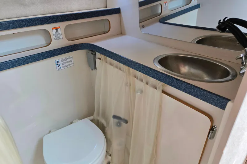 Slide: The Image of 1995 Regal Commodore 258 boat bathroom with sink, toilet, and mirror. - 6