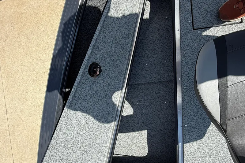 Slide: The Image of 2025 Lund 2075 Impact XS boat interior with gray carpet and seating. - 12