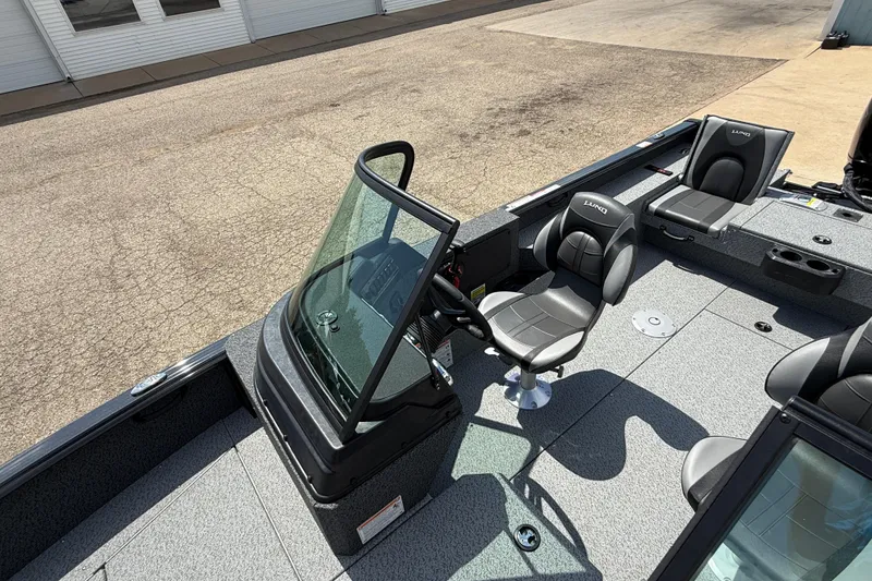 Slide: The Image of 2025 Lund 2075 Impact XS boat interior with steering console and seating. - 18