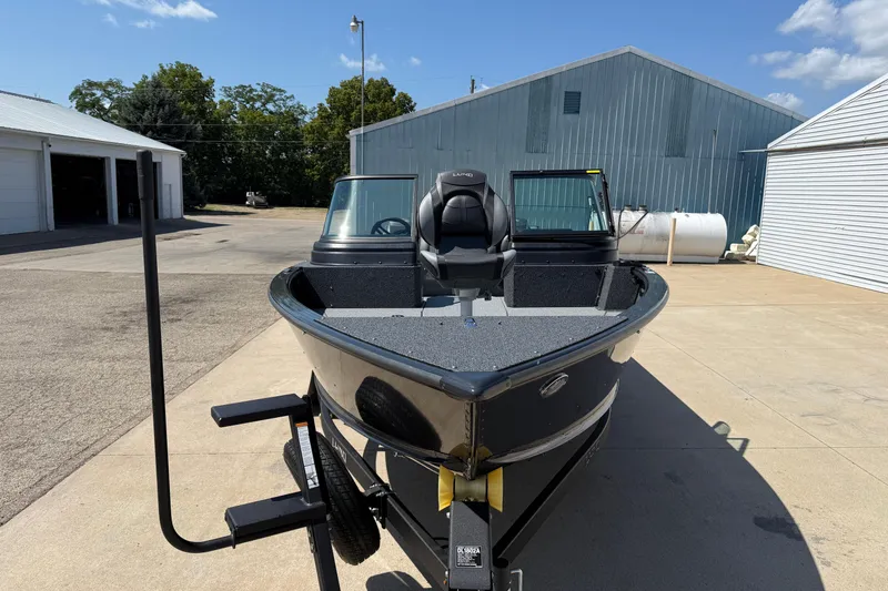 Slide: The Image of 2025 Lund 2075 Impact XS boat on trailer in sunny outdoor setting. - 2