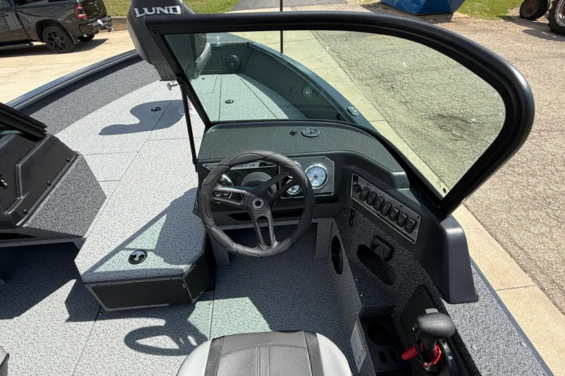 Slide: The Image of 2025 Lund 2075 Impact XS boat interior with steering wheel and dashboard controls. - 21