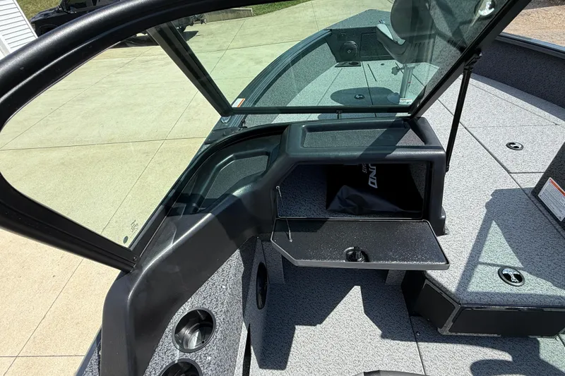 Slide: The Image of 2025 Lund 2075 Impact XS boat interior with open storage compartment and windshield. - 24