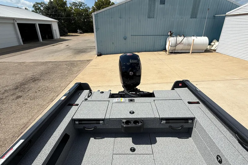 Slide: The Image of 2026 Lund 2075 Impact XS boat, rear view, parked on concrete near blue building. - 31