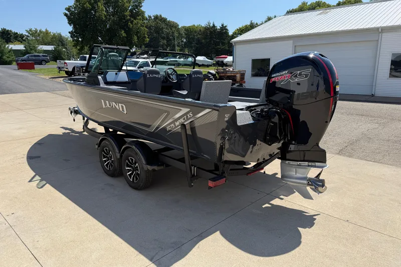 Slide: The Image of 2025 Lund 2075 Impact XS boat on trailer, parked outdoors near a building. - 5