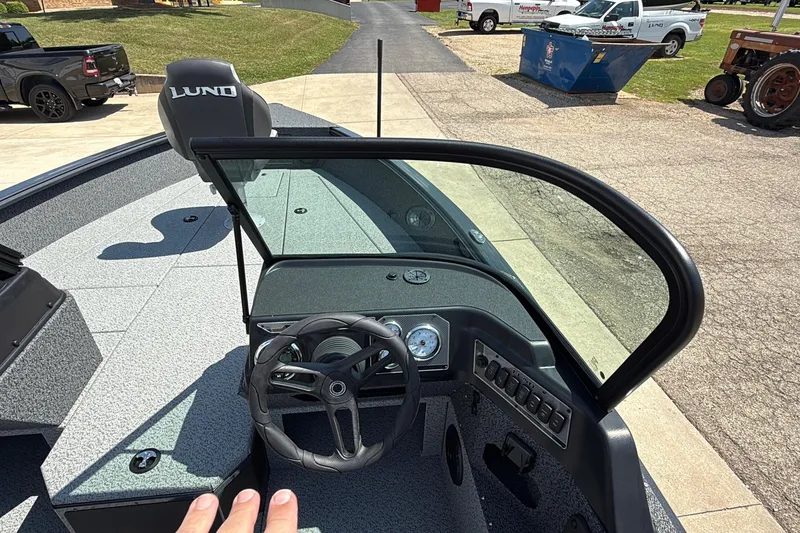 Slide: The Image of 2025 Lund 2075 Impact XS boat interior with steering wheel and dashboard controls. - 9