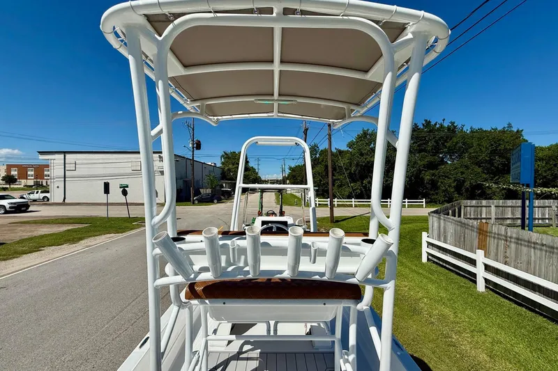 Slide: The Image of 2022 Shallow Sport 24 Modified V boat with T-top on a sunny street. - 11