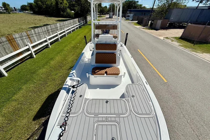 Slide: The Image of 2022 Shallow Sport 24 Modified V boat on road, showcasing deck and seating. - 15