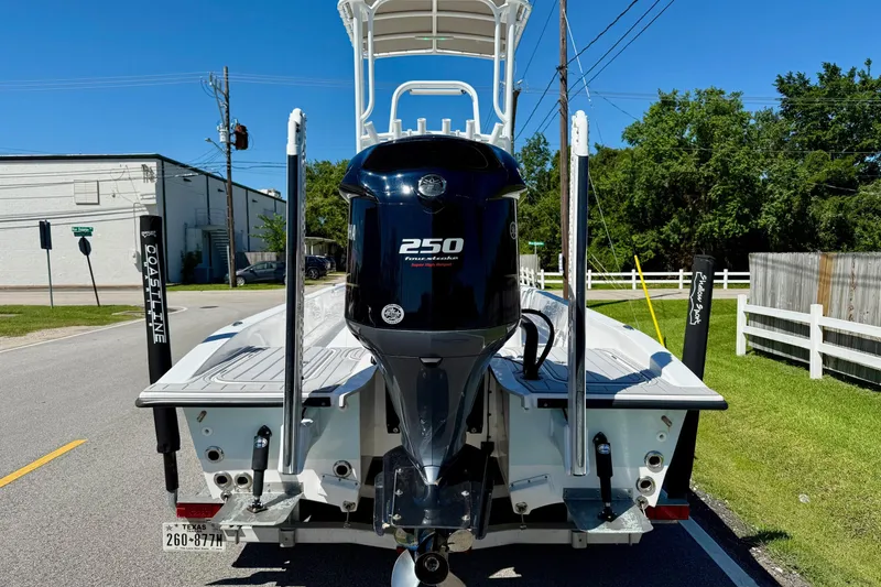 Slide: The Image of 2022 Shallow Sport 24 Modified V boat with powerful 250 horsepower engine, parked on street. - 3