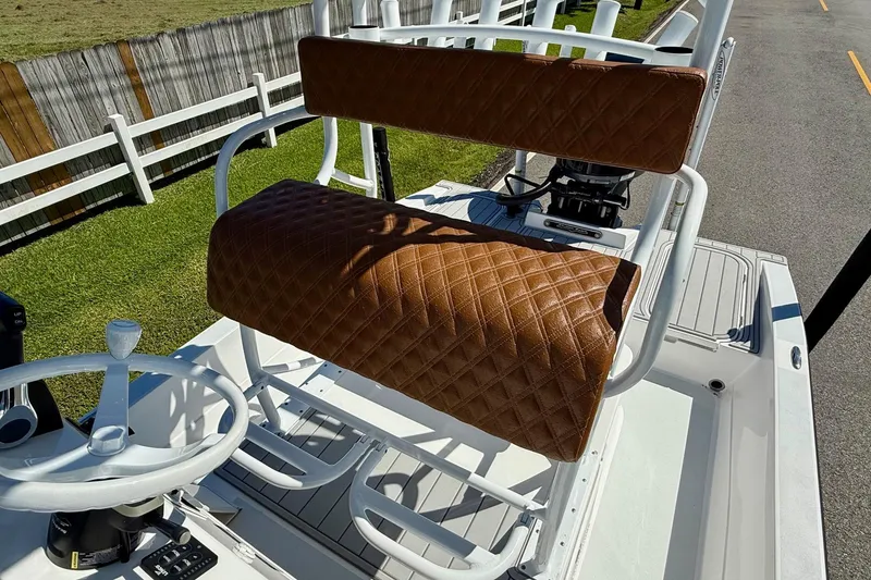Slide: The Image of 2022 Shallow Sport 24 Modified V boat with brown diamond-stitched seating and white steering wheel. - 9