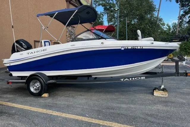 Slide: The Image of 2018 Tahoe 550 TF boat on trailer, blue and white design, parked outdoors. - 1