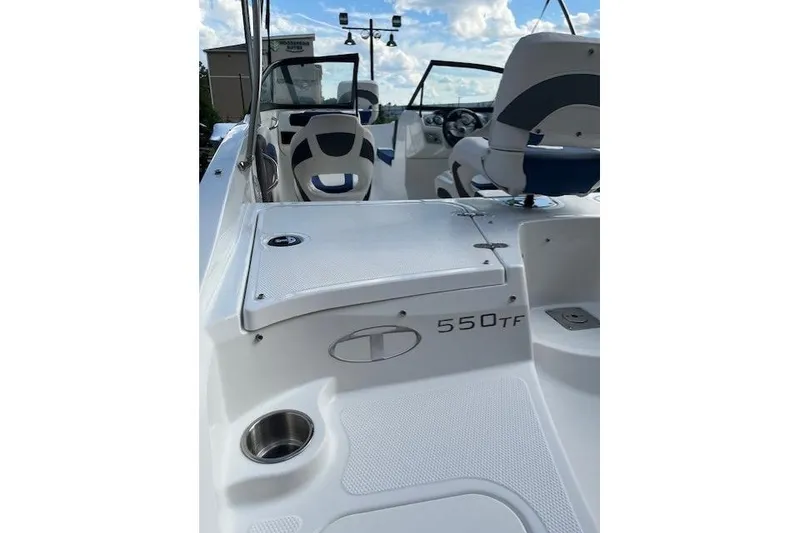 Slide: The Image of 2018 Tahoe 550 TF boat interior with seating and dashboard, under a blue sky. - 3