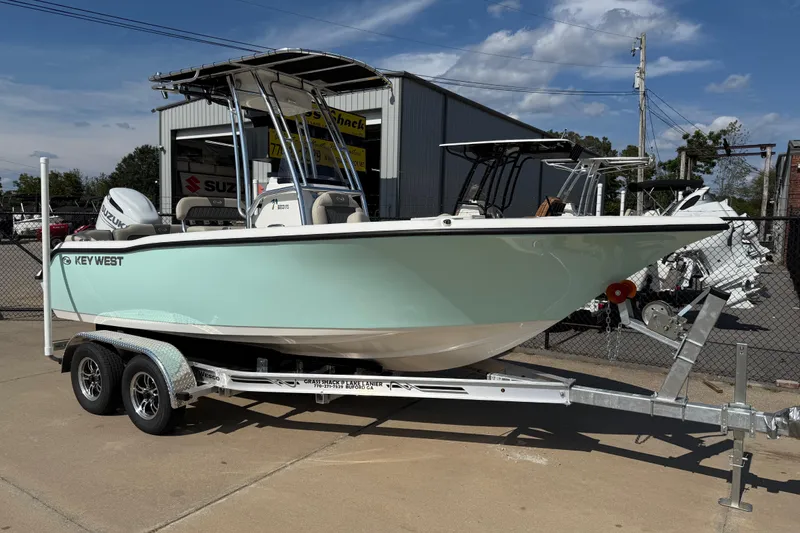 The Image of 2026 Key West 203 FS boat on trailer, parked outdoors under blue sky. - 0