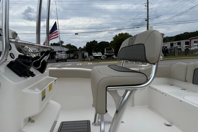 Slide: The Image of 2026 Key West 203 FS boat interior with seating and control panel, American flag in background. - 19