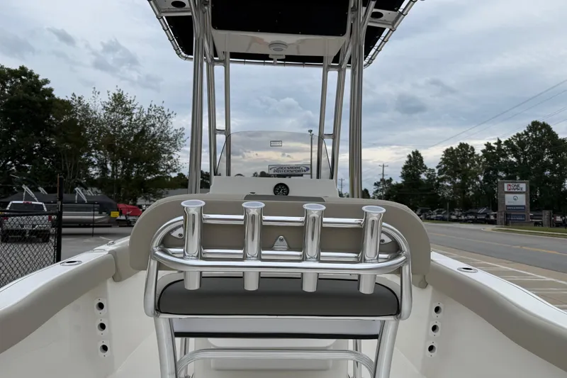 Slide: The Image of 2026 Key West 203 FS boat interior with rod holders and seating, parked outdoors. - 23