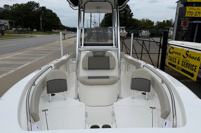 Slide: The Image of 2026 Key West 203 FS boat interior at dealership, featuring seating and console. - 7