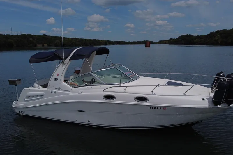 The Image of 2006 Sea Ray 260 Sundancer boat on a calm lake under a partly cloudy sky. - 0