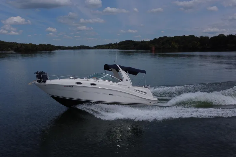 Slide: The Image of 2006 Sea Ray 260 Sundancer cruising on a calm lake under a blue sky. - 10