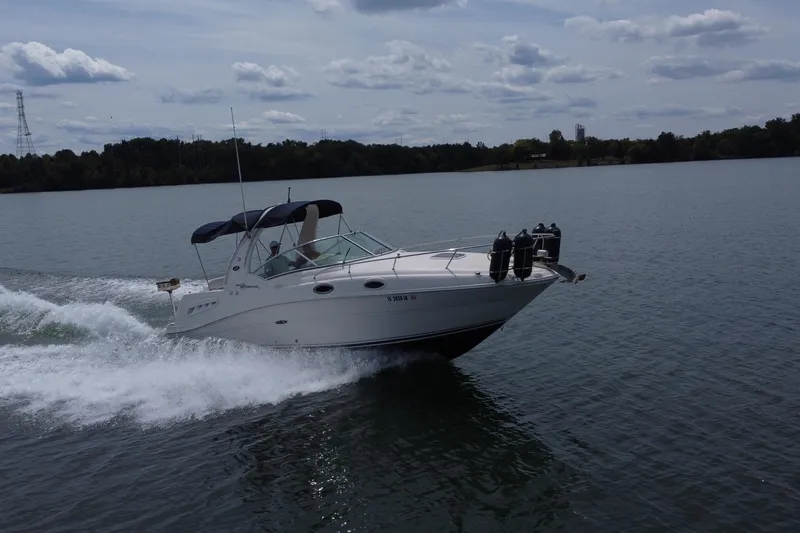 Slide: The Image of 2006 Sea Ray 260 Sundancer cruising on a lake under a cloudy sky. - 11
