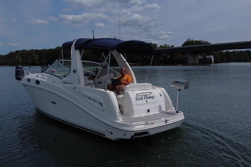 Slide: The Image of 2006 Sea Ray 260 Sundancer boat on calm water near a bridge. - 12