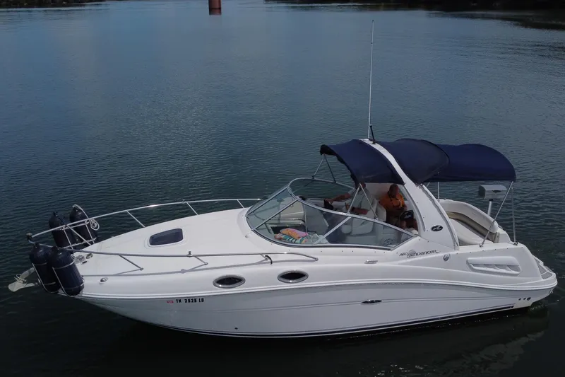 Slide: The Image of 2006 Sea Ray 260 Sundancer boat on calm water, featuring a sleek white design and blue canopy. - 14