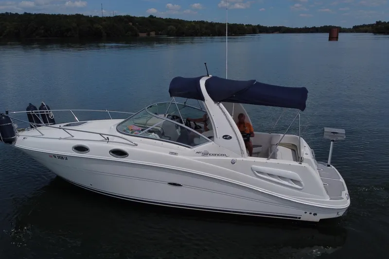Slide: The Image of 2006 Sea Ray 260 Sundancer boat cruising on a calm lake under a clear sky. - 5