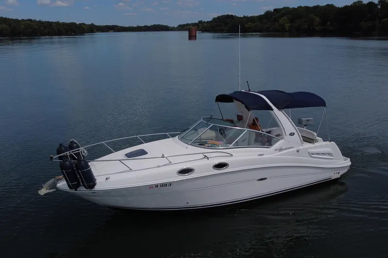 Slide: The Image of 2006 Sea Ray 260 Sundancer cruising on a serene lake under a clear sky. - 7