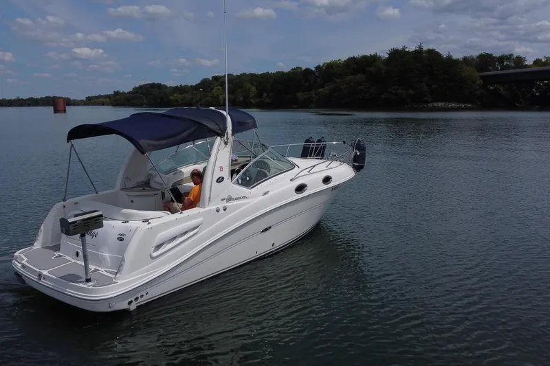 Slide: The Image of 2006 Sea Ray 260 Sundancer boat cruising on a calm lake under a partly cloudy sky. - 8