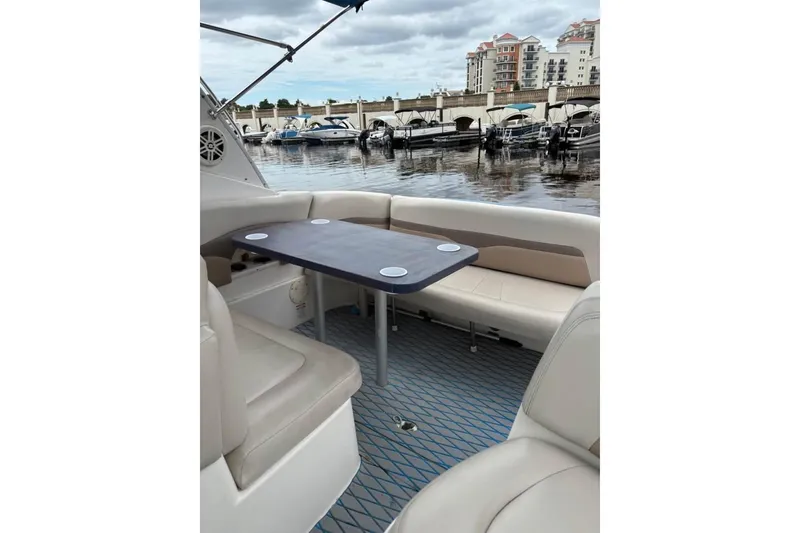 Slide: The Image of 2005 Chaparral 290 Signature boat interior with seating and table, docked at marina. - 13