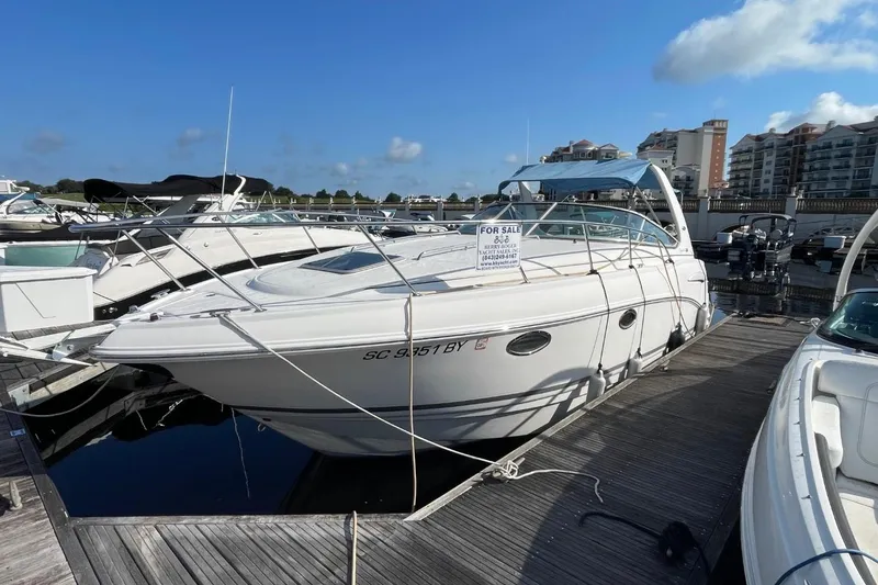 Slide: The Image of 2005 Chaparral 290 Signature boat docked, for sale sign visible, clear sky background. - 2
