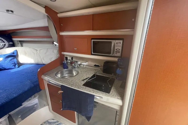 Slide: The Image of 2005 Chaparral 290 Signature boat interior with kitchenette and bed. - 6
