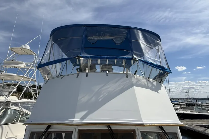 Slide: The Image of 1999 Grand Banks 42 Classic yacht with blue canopy, docked under a clear sky. - 10